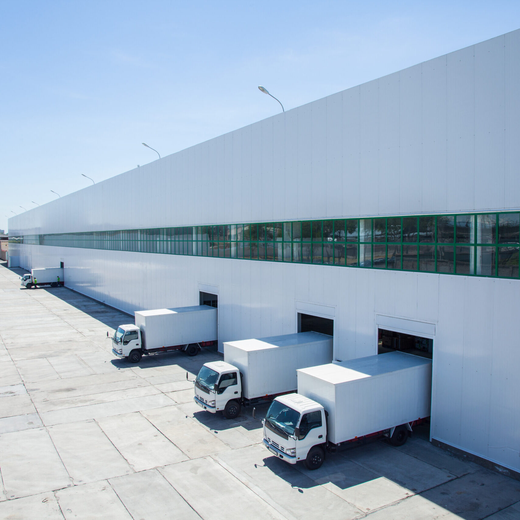 facade of an industrial building and warehouse with freight cars in length